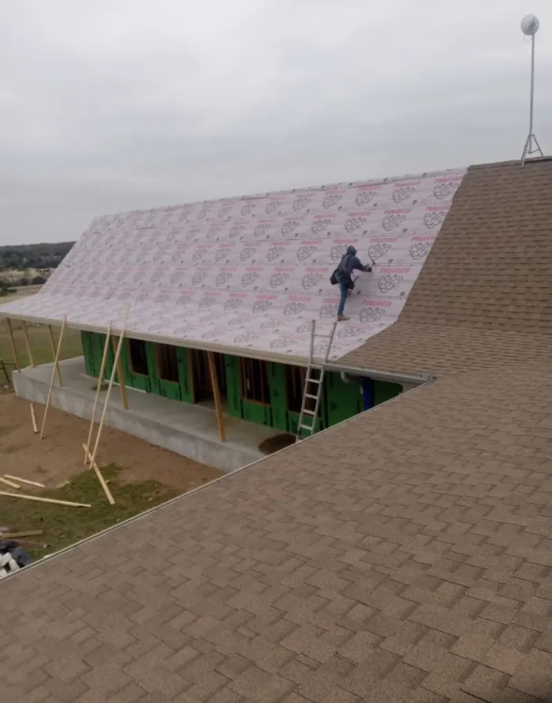 Worker preparing underlayment for a metal roof installation in Saugerties